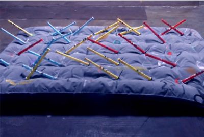 Blauw elektrisch matras dat een muziekinstrument vormt samen met de gekleurde fluiten die eraan vast zitten.